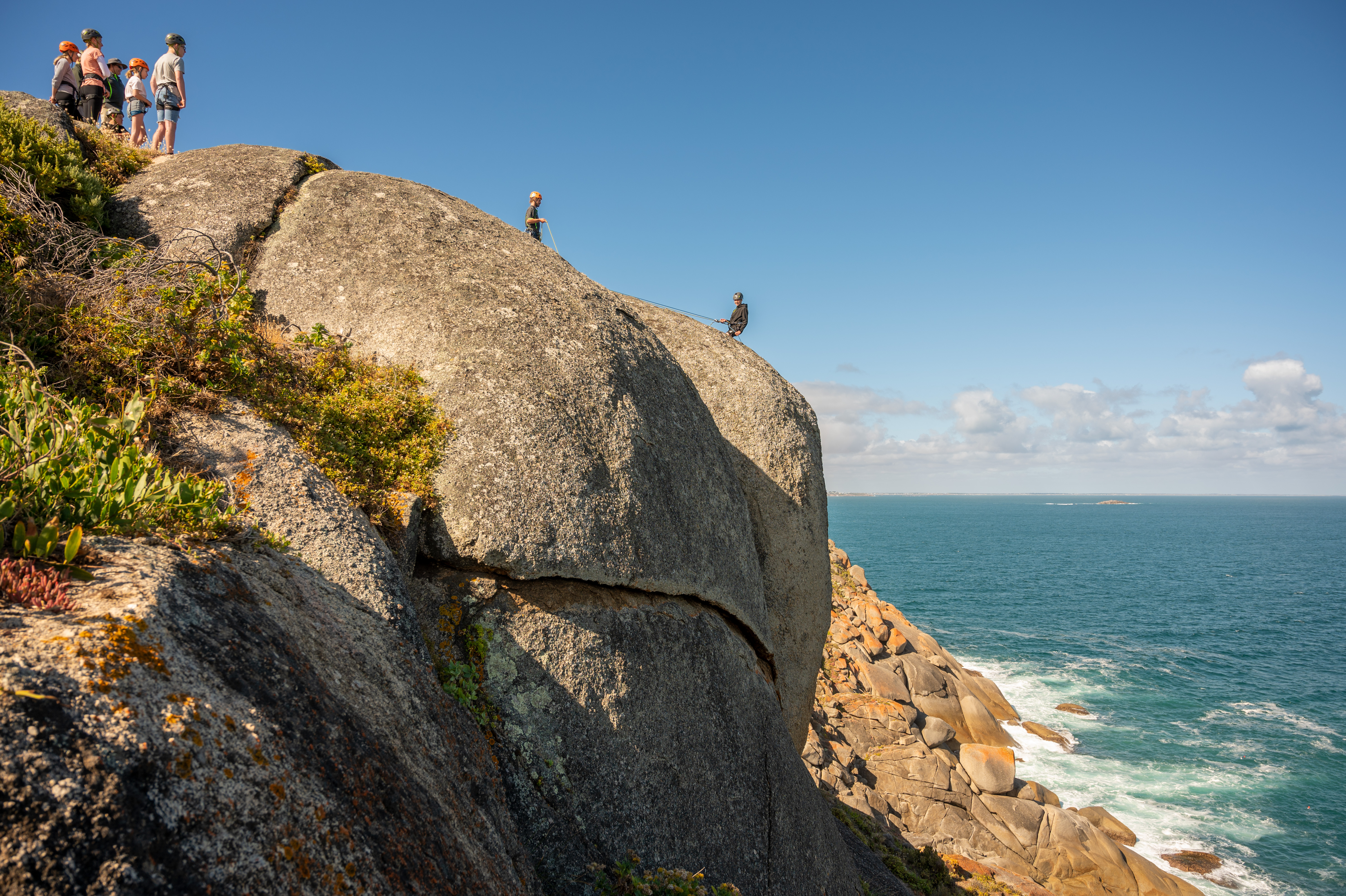 Group Abseiling Off The Bluff